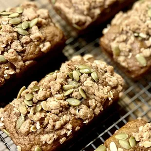 mini pumpkin loaf with fresh cranberries topped with a brown sugar crumble and toasted pumpkin seeds