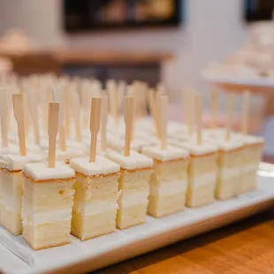 a plate of mini cakes with toothpicks on them