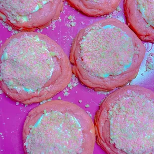 a tray of pink cookies with sprinkles