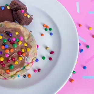 a white plate with chocolate and sprinkles