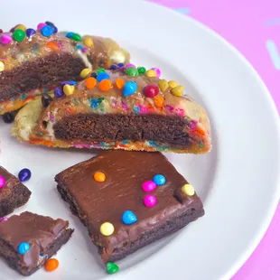 a plate of brownies with chocolate frosting and sprinkles