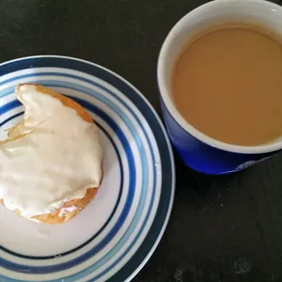 Enjoying the orange cream filled donut with a hot cup of coffee