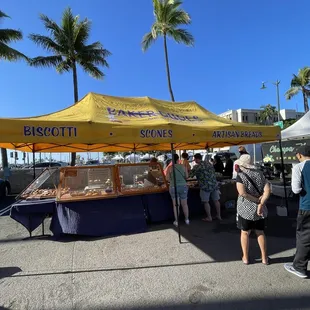 a group of people standing under a yellow tent