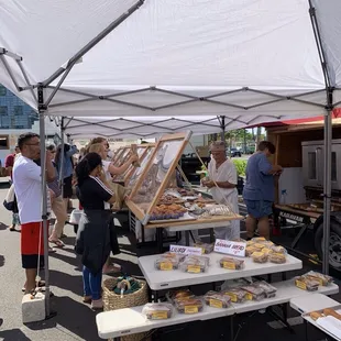 Busy, busy!  Note their portable oven to the right behind the display case and they've changed their tents to a bright white..