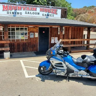 a blue motorcycle parked in front of a restaurant