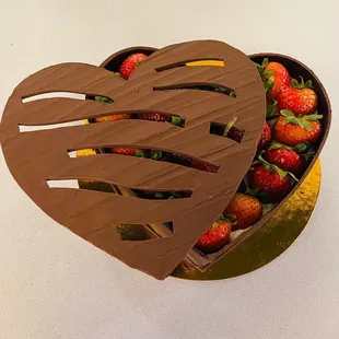 a heart shaped box of strawberries