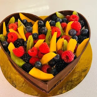 a heart shaped chocolate cake with fruit