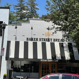 a red car parked in front of a bakery