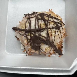 This is like a macaroon scone, not sure of the name but it has toasted coconut with icing and chocolate drizzled and it's very good