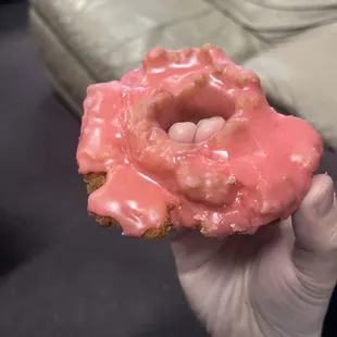 a hand holding a glazed donut