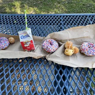 doughnuts with sprinkles and a carton of milk