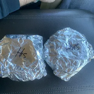 two sandwiches wrapped in aluminum foil