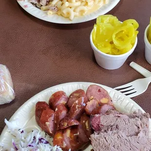 FAR plate is pulled pork, mac n cheese, baked beans. Close plate jalapeno cheddar sausage, brisket, coleslaw, loaded mashed potatoes