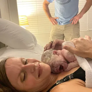 A mother holding her newborn baby that was born in the water at the birth center.