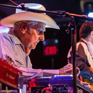 a man in a cowboy hat playing a keyboard