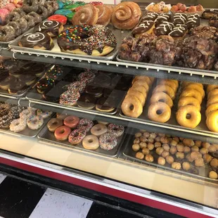 a variety of doughnuts in a display case