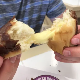 a person holding a half eaten doughnut