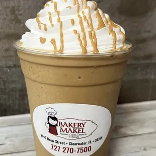 ows a cup of coffee with whipped cream and caramel