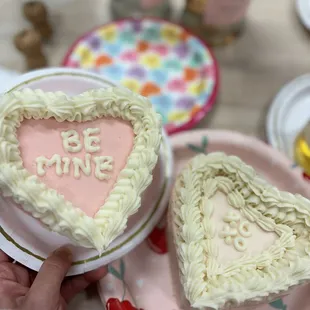 someone holding a heart shaped cake
