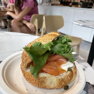 a sandwich with salmon and lettuce on a white plate