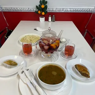 a table with soup, bread, and other dishes