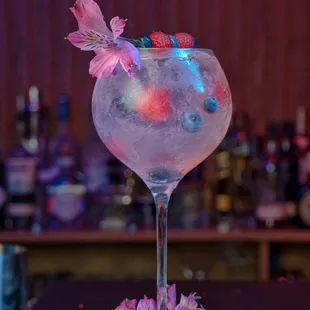 a glass of water with a flower on the table