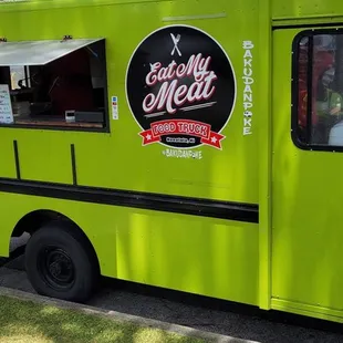 a green food truck parked on the side of the road