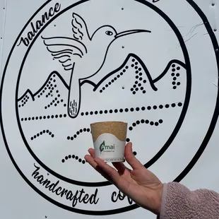 a hand holding a cup of coffee