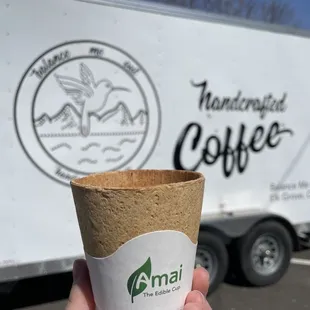 a hand holding a cup of coffee