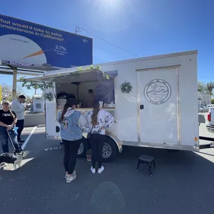a group of people standing in front of a food truck