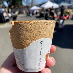 a hand holding a paper cup