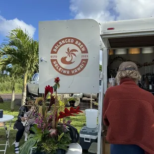 a woman standing in front of a food truck