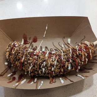 Frozen banana with almonds, toasted coconut, and drizzles: marshmallow, Nutella, biscoff, rasberry