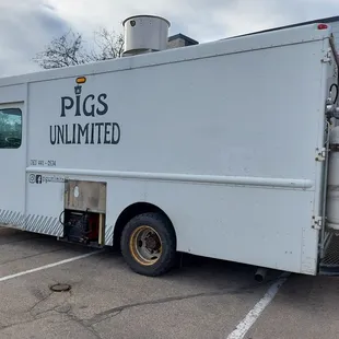 a pig's unlimited truck parked in a parking lot