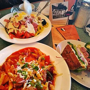 two plates of pasta and a sandwich