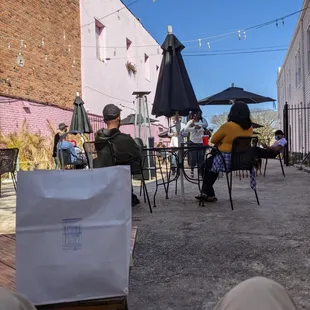 a group of people sitting at tables with umbrellas