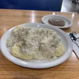 Biscuits and gravy (pepper by my hand) and a sausage patty.