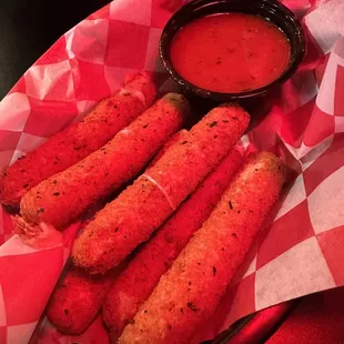 a basket of chicken sticks with dipping sauce