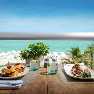 two plates of food on a table overlooking the ocean