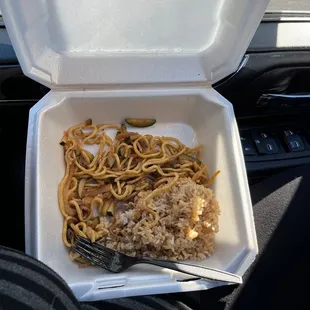 a take out container with noodles and a fork