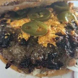 Gourmet burger with urnebes and jalapeno.