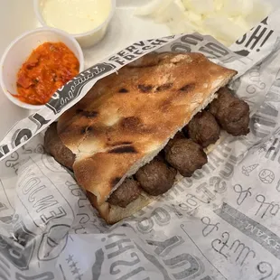 Small cevapi with cheese and vegetable sauces with onions