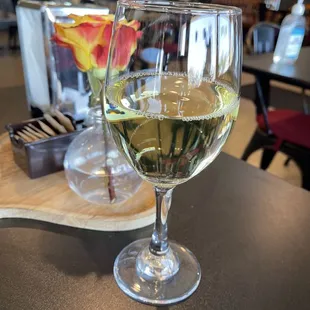 a glass of white wine on a table