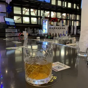 a glass of whiskey on the bar