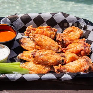 a basket of chicken wings and celery