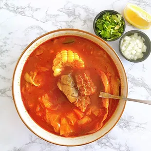 DELIVERY - Mondongo: Tripe soup w/ pata, corn, cabbage, carrots, zucchini, two handmade Salvadoran tortillas not shown | $14.99