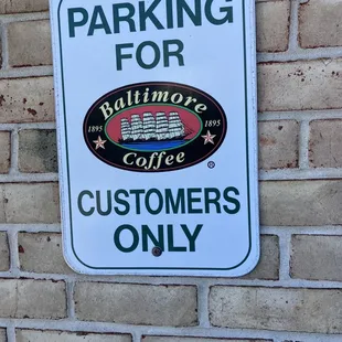 a parking sign on a brick wall