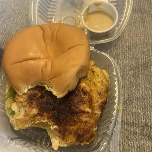 a crab cake sandwich in a plastic container