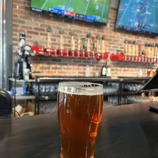 a pint of beer on a bar