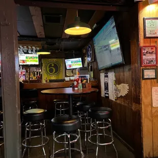 a bar with stools and a television